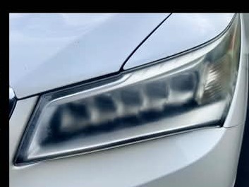 White vehicle headlight before detailing
